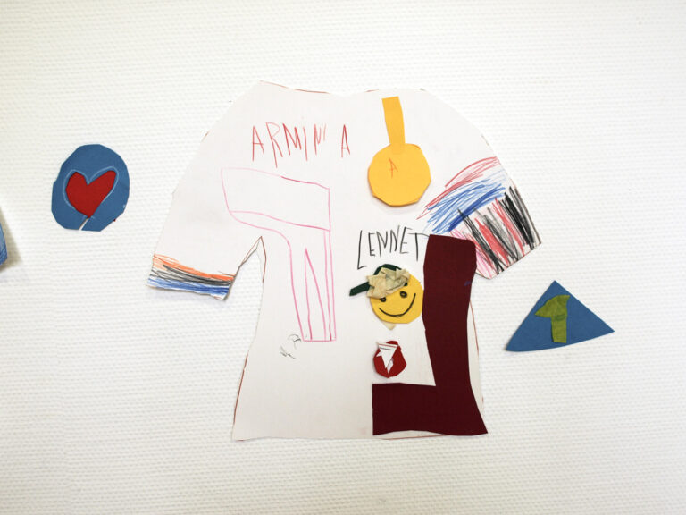 T-Shirt Kontur aus Karton, der von einem Kind bemalt und mit Tonpapier beklebt wurde