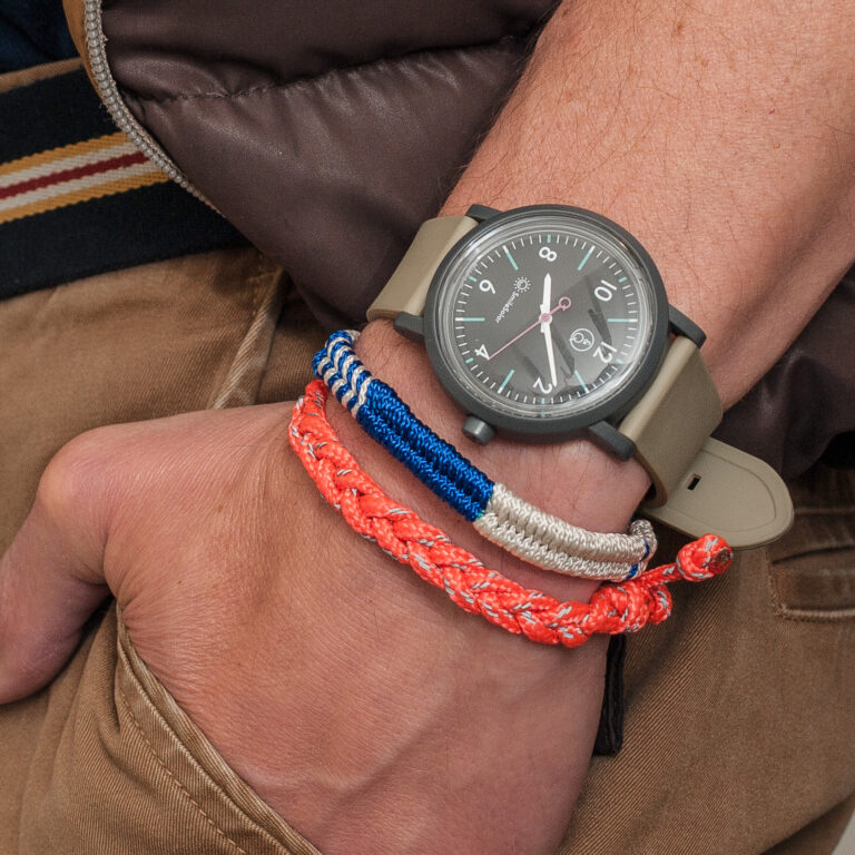 Armgelenk mit Uhr und bunten Freundschaftsbändchen